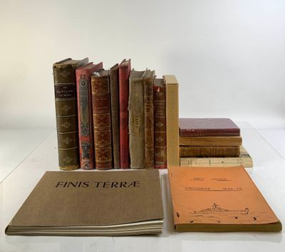 Plusieurs vieux livres sont empilés sur une table blanche, à côté d'une pile de livres