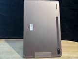 a laptop and a pen sitting on a wooden table