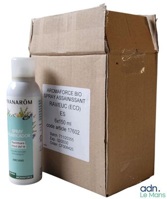 une photo d'un flacon de spray posé à côté d'une boîte en carton