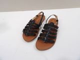 black leather sandals with braid straps on a white surface