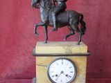 statue of a man riding a horse on top of a clock