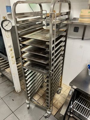 Plusieurs plateaux de nourriture sont posés sur une grille métallique dans une cuisine