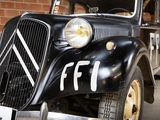 a black car that is parked in front of a brick wall