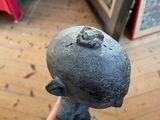 a person that is holding a stone statue in their hand