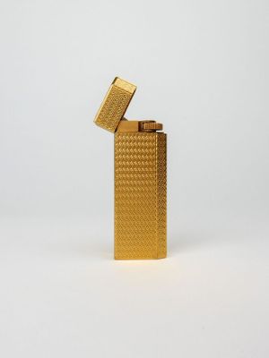 un briquet doré posé sur une surface blanche