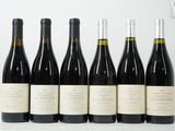 six bouteilles de vin sont alignées sur une table
