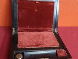 une petite boîte en bois doublée de velours rouge
