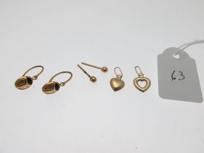 trois paires de boucles d'oreilles et une étiquette sur un fond blanc