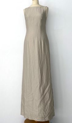 La robe est en lin et présente un décolleté froncé.