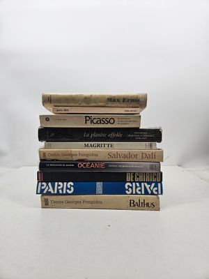plusieurs livres empilés sur une surface blanche
