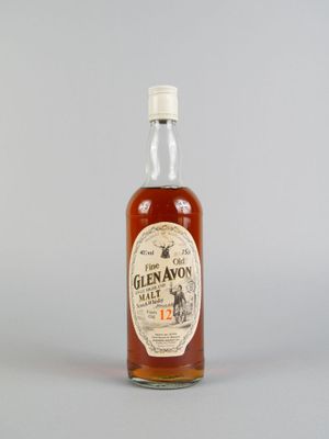 un gros plan d'une bouteille de whisky posée sur une surface blanche