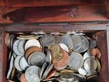 a small wooden box filled with coins and coins