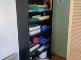 a tall black bookcase with many books on it