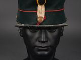 a green hat with a red ribbon on top of it
