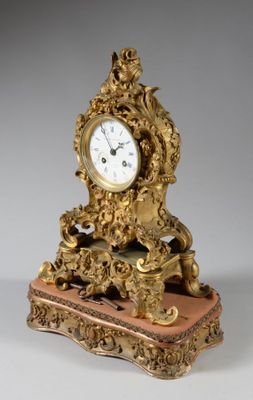 a gold clock sitting on top of a marble block