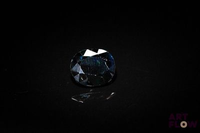 a dark blue diamond on a black surface