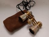 an old pair of binoculars sitting on top of a brown bag