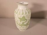 a white vase with a green dragon design on it