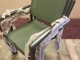 une chaise verte qui a été emballée et qui se trouve par terre