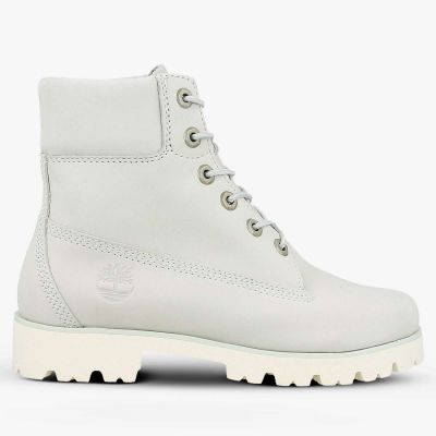 une paire de bottes blanches à semelles blanches sur fond blanc