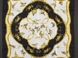 a black and white square scarf with a gold and black floral design