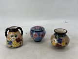 three small vases sitting on top of a white surface