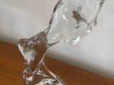 une sculpture en verre représentant une tête d'homme posée sur une table en bois