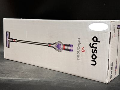 the box is open on a table with a cordless vacuum in it