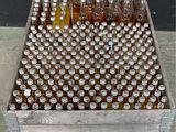 many bottles of beer in a wooden crate on the floor