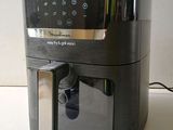 an air fryer sitting on a counter top with a digital clock on it