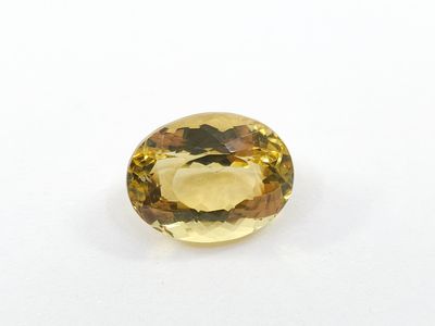 a yellow sapphire stone on a white surface