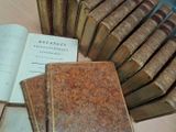 Plusieurs vieux livres sont empilés sur une table, à côté d'une pile de vieux livres