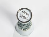 a small vase with a message on it on a white surface