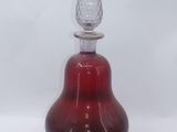 a red glass bottle with a silver top