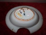 a white bowl with a clock on it on a red table