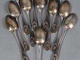 six silver spoons are arranged in a circle on a table