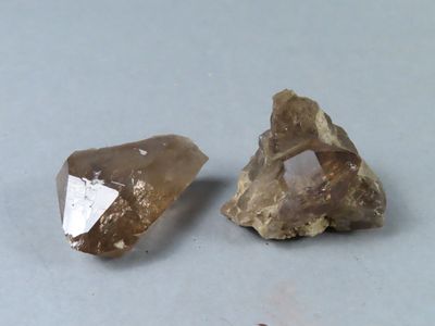 deux morceaux de quartz marron et blanc sur une surface grise