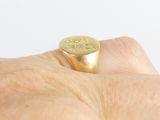 a person holding a gold ring with a coin on it