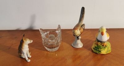three figurines of cats and a bird sitting on a table