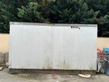 a white box sitting in the middle of a parking lot