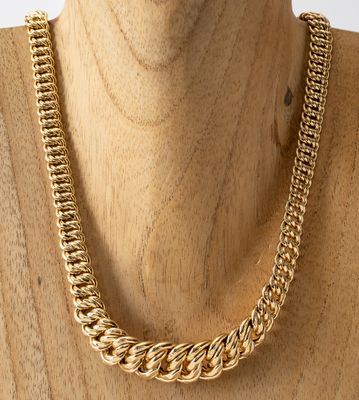 un gros plan sur un mannequin portant un collier à chaîne en or