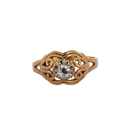 gros plan d'une bague en or avec un diamant au centre