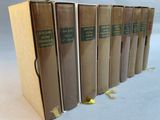 six books are lined up in a row on a white surface