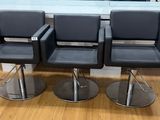 three black chairs sitting on top of a wooden floor next to a window