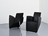 two black chairs in a room with a white wall