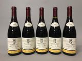 six bottles of wine are lined up on a table