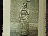 a picture of a woman in a dress standing in front of a wall