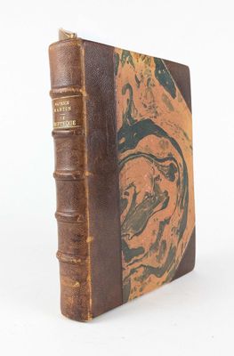 un vieux livre à la couverture brune posé sur une surface blanche