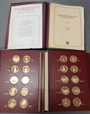 trois livres contenant des pièces d'or et d'argent, posés sur une table