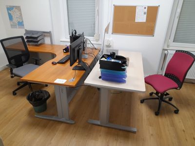 a desk with two chairs and a computer on it